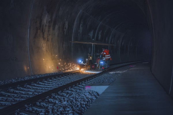A worker in an orange waistcoat works on the rails in a dark tunnel while sparks fly, grinding work on the Hermann Hesse railway, Ostelsheim, district of Calw, Germany
