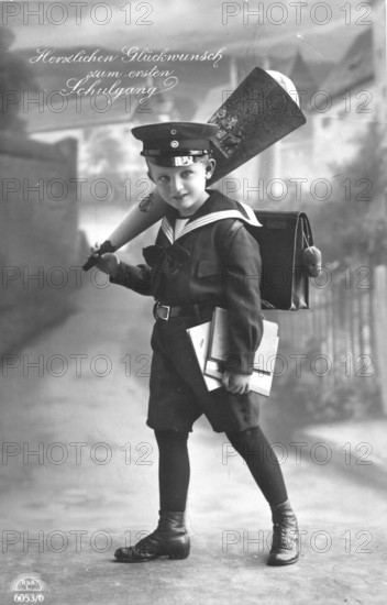 School enrolment, 1920s, A boy in school uniform with school bag and cone in a studio, Historical photo