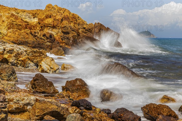 Rugged rocks and foaming spray on Topinetti beach, near Rio Marina, Elba Island, Tuscan Archipelago National Park, Tuscany, Italy