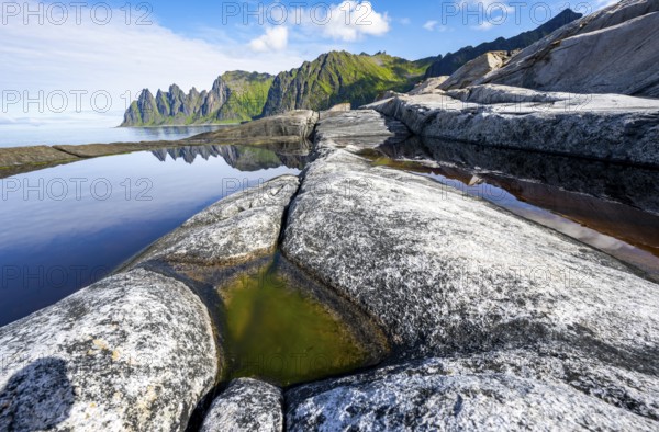 Reflection in a tidal pool, rocky coast of Tungeneset, Devil's Teeth, Okshornan, Ersfjorden, Senja Island, Troms, Norway