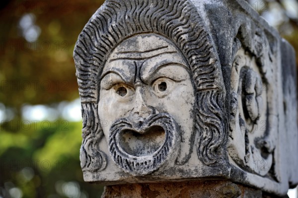 Ancient stone sculpture, stone carving of a mask, Roman theatre, ancient port city of Rome, excavation site Archaeological Park Ostia Antica, metropolitan city of Rome, Lazio, Italy
