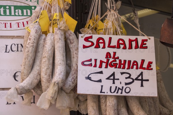 Italian market stall with wild boar salami and price tag, Tuscany, Italy