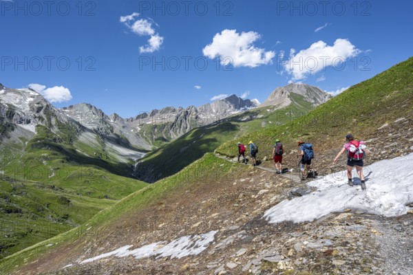 Group of mountaineers on a hiking trail on the Daberlenke, view of rocky mountain peaks in the Karbachtal valley with Tredebergspitze, Lasörling Höhenweg, Lasörlinggruppe, Hohe Tauern National Park, East Tyrol, Tyrol, Austria