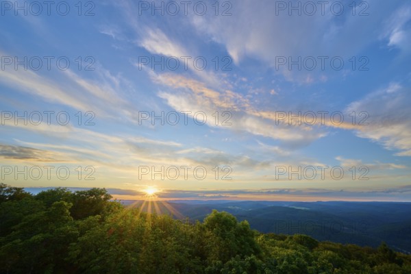 Sunset over green forests, the sky tinted in blue and orange, Katzenbuckel, Waldbrunn, Neckar-Odenwald-Kreis, Odenwald, Baden-Württemberg, Germany