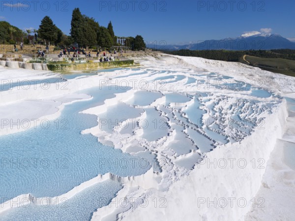 View of limestone terraces with turquoise blue water surrounded by trees and tourists, aerial view, sinter terraces, limestone terraces, travertine terraces, Pamukkale, Denizli, UNESCO World Heritage Site, Anatolia, Turkey
