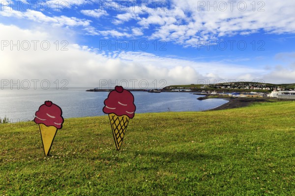 Two ice-cream cones in summer, signs in a meadow by the sea, fun decoration on Candy Day, Cumulus, town festival in Husavik, Húsavík, North Iceland, Iceland
