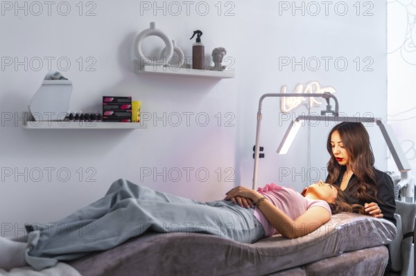 Beautician carefully examining a customer's face, preparing for a cosmetic treatment in a modern beauty salon