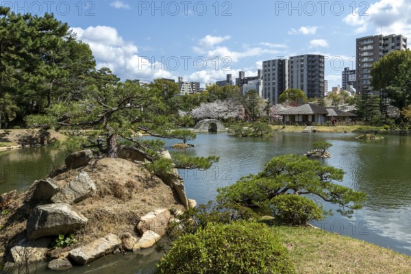 Shukkei-en with Sekisui-gan stone formation, green plants, trees and Koko-kyo stone bridge over Takuei-chi pond in spring, historical Japanese strolling garden, Japanese garden, green area, tourist attraction, sight, Naka-ku, Hiroshima, Japan