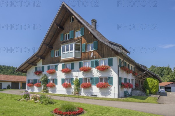 Renovated farmhouse with floral decorations, Frauenzel, Allgäu, Bavaria, Germany