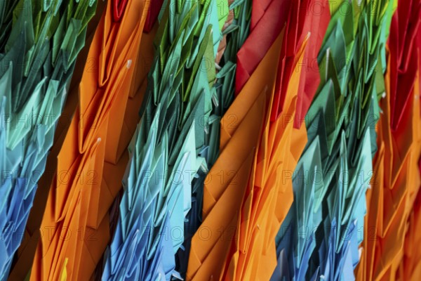 Chains of colourful origami cranes made of paper as a sign of peace in the Peace Park, close-up, background image, landmark, UNESCO World Heritage Site, peace memorial and memorial to the victims of the atomic bombing of Hiroshima, Naka Ward, Hiroshima, Japan