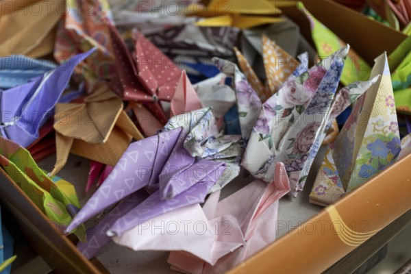 Colourful origami cranes made of paper as a sign of peace in the Peace Park, close-up, background image, landmark, UNESCO World Heritage Site, peace memorial and memorial to the victims of the atomic bombing of Hiroshima, Naka Ward, Hiroshima, Japan