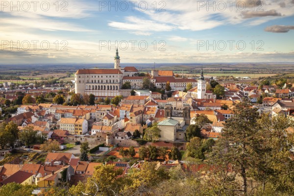 Panorama of a historic town with castle and churches, surrounded by autumn trees and a wide sky, Mikulov Nikolsburg Czech Republic