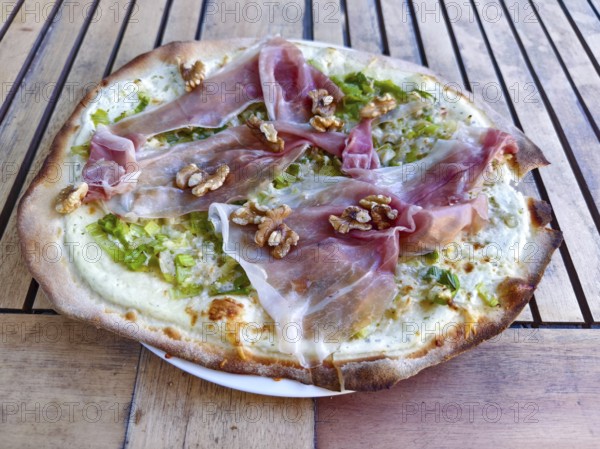 Close-up of a pizza tarte flambée with raw ham and walnuts, crispy base, served to a high standard, Lower Austria Austria