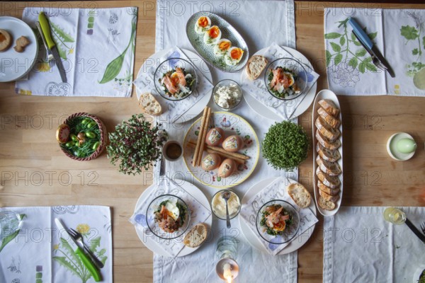 A stylishly laid table with a selection of fresh dishes, decorated with herbs and candlelight, Lower Austria Austria