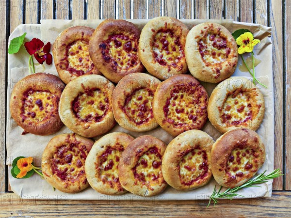 Small pizzas on baking board decorated with flowers and rosemary, bird's eye view, Lower Austria Austria