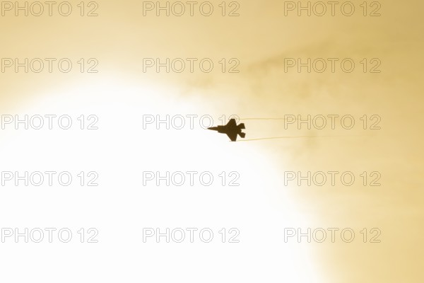 Lockheed Martin F-35 Lightning II fighter military aircraft of the United States air force USAF silhouette in flight at sunset at RAF Lakenheath airbase, Suffolk, England, United Kingdom