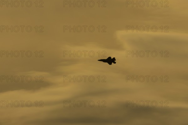 Lockheed Martin F-35 Lightning II fighter military aircraft of the United States air force USAF silhouette in flight at sunset at RAF Lakenheath airbase, Suffolk, England, United Kingdom