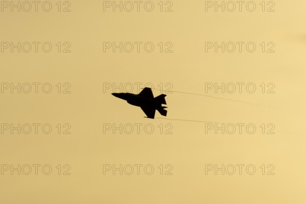 Lockheed Martin F-35 Lightning II fighter military aircraft of the United States air force USAF silhouette in flight at sunset at RAF Lakenheath airbase, Suffolk, England, United Kingdom