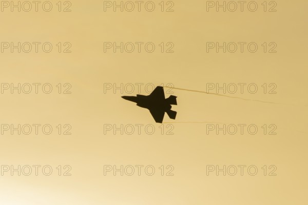 Lockheed Martin F-35 Lightning II fighter military aircraft of the United States air force USAF silhouette in flight at sunset at RAF Lakenheath airbase, Suffolk, England, United Kingdom