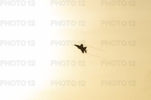Lockheed Martin F-35 Lightning II fighter military aircraft of the United States air force USAF silhouette in flight at sunset at RAF Lakenheath airbase, Suffolk, England, United Kingdom