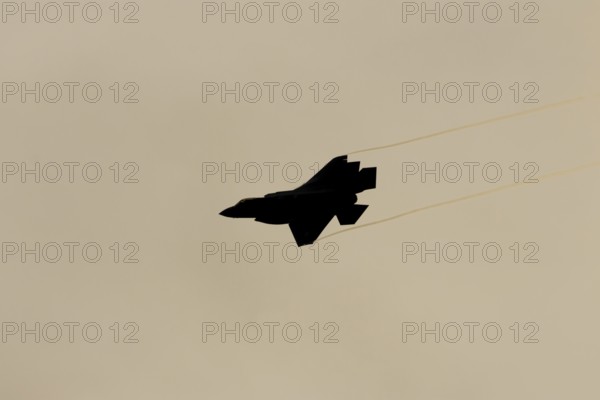 Lockheed Martin F-35 Lightning II fighter military aircraft of the United States air force USAF silhouette in flight at sunset at RAF Lakenheath airbase, Suffolk, England, United Kingdom