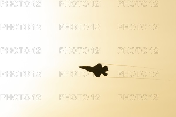 Lockheed Martin F-35 Lightning II fighter military aircraft of the United States air force USAF silhouette in flight at sunset at RAF Lakenheath airbase, Suffolk, England, United Kingdom