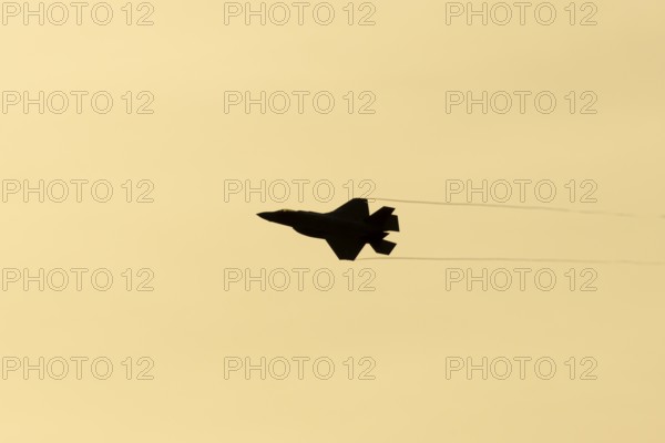 Lockheed Martin F-35 Lightning II fighter military aircraft of the United States air force USAF silhouette in flight at sunset at RAF Lakenheath airbase, Suffolk, England, United Kingdom