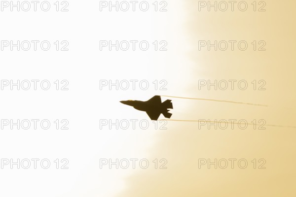 Lockheed Martin F-35 Lightning II fighter military aircraft of the United States air force USAF silhouette in flight at sunset at RAF Lakenheath airbase, Suffolk, England, United Kingdom