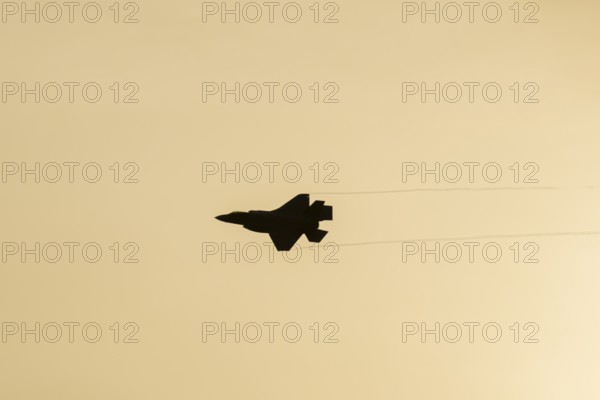 Lockheed Martin F-35 Lightning II fighter military aircraft of the United States air force USAF silhouette in flight at sunset at RAF Lakenheath airbase, Suffolk, England, United Kingdom