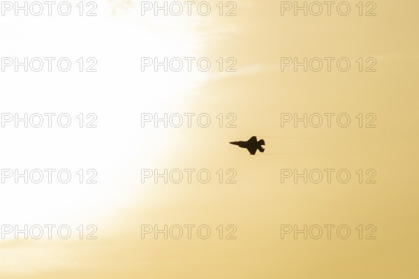 Lockheed Martin F-35 Lightning II fighter military aircraft of the United States air force USAF silhouette in flight at sunset at RAF Lakenheath airbase, Suffolk, England, United Kingdom