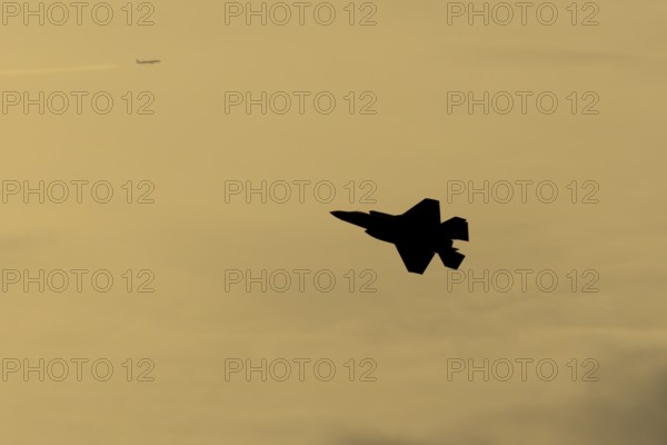 Lockheed Martin F-35 Lightning II fighter military aircraft of the United States air force USAF silhouette in flight at sunset at RAF Lakenheath airbase, Suffolk, England, United Kingdom