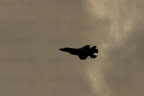 Lockheed Martin F35 Lightning II fighter military aircraft of the United States air force USAF silhouette in flight at sunset at RAF Lakenheath airbase, Suffolk, England, United Kingdom