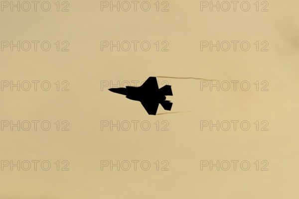Lockheed Martin F35 Lightning II fighter military aircraft of the United States air force USAF silhouette in flight at sunset at RAF Lakenheath airbase, Suffolk, England, United Kingdom