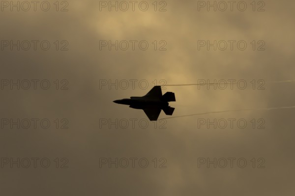 Lockheed Martin F-35 Lightning II fighter military aircraft of the United States air force USAF silhouette in flight at sunset at RAF Lakenheath airbase, Suffolk, England, United Kingdom