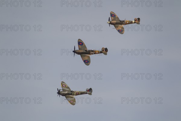 Supermarine Spitfire three warbird military aircraft in Royal air force RAF colours flying, England, United Kingdom
