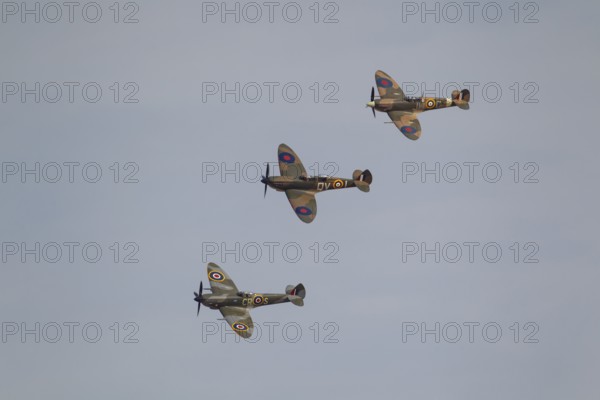 Supermarine Spitfire three warbird military aircraft in Royal air force RAF colours flying, England, United Kingdom