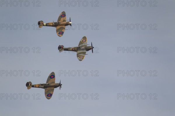 Supermarine Spitfire three warbird military aircraft in Royal air force RAF colours flying, England, United Kingdom