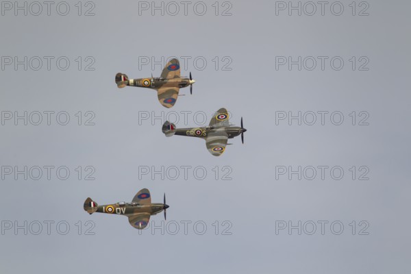 Supermarine Spitfire three warbird military aircraft in Royal air force RAF colours flying, England, United Kingdom
