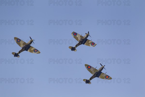 Supermarine Spitfire three warbird military aircraft in Royal air force RAF colours flying, England, United Kingdom