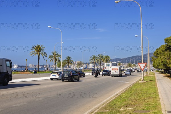 Traffic with cars and motorbike on a city road to Palma by the sea a sunny summer day, Palma de Mallorca, Mallorca, Spain