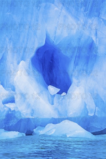 Blue ice cave on a glacier by the sea in arctic, Svalbard, Norway