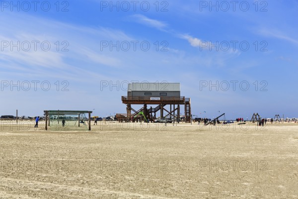 Pile dwelling, toilet block on the beach, football goal, walkers on the horizon, Sankt Peter-Ording, Eiderstedt peninsula, Wadden Sea National Park, North Frisia, Schleswig-Holstein, Germany