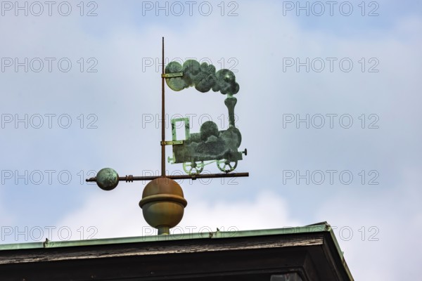 Steam locomotive with lots of smoke. Weather vane on the roof of the main railway station. Freudenstadt, Baden-Württemberg, Germany