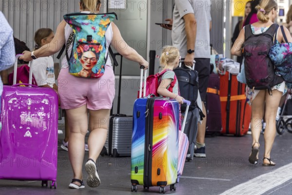 Stuttgart main station. Group of travellers on the platform with colourful suitcases. Stuttgart, Baden-Württemberg, Germany