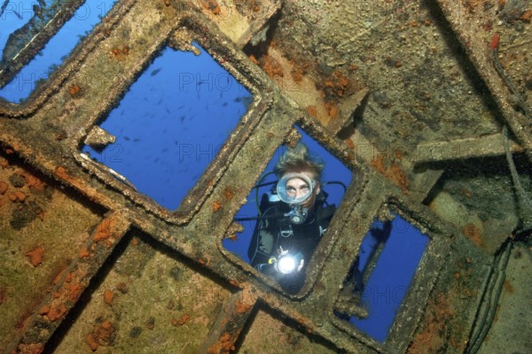 Diver looking from outside into wreck ship El Peñon, East Atlantic, Tabaita, Tenerife, Canary Islands, Spain