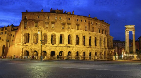 View at dusk blue hour on the left illuminated historical Marcellus Theatre Theatre of Marcellus on the right illuminated columns of ruins of Temple of Apollo Temple of Apollo Medicus from antiquity on Mars Field in today's centre of Rome, Rome, Lazio, Italy