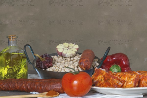 Raw chickpeas in a casserole with the ingredients to make the stew