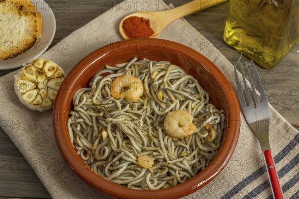 Gulas with garlic prawns in earthenware casserole dish