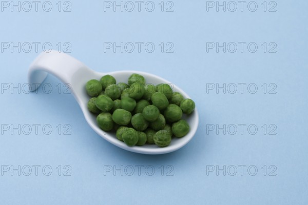 White ceramic spoon with peas and blue bottom