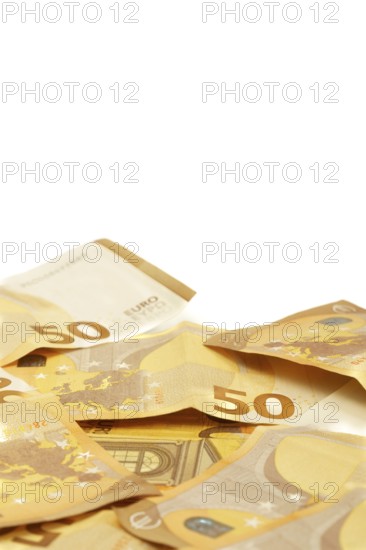 Scattered fifty euro banknotes forming a corner frame on a white background, ideal for finance and investment concepts